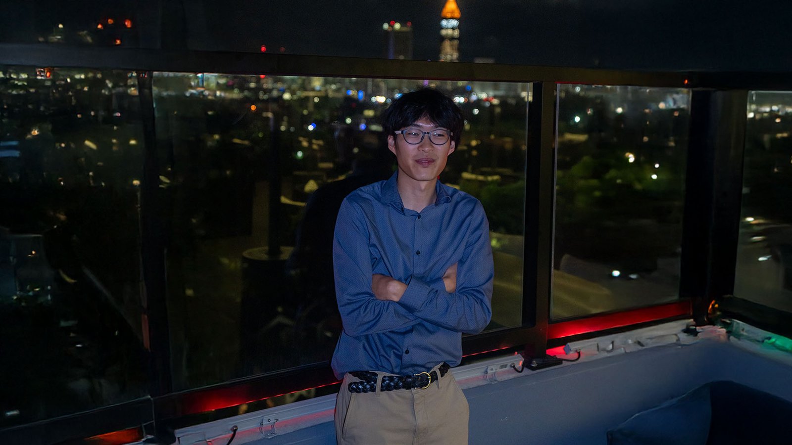 James Pilsung standing, arms crossed, in front of a clear railing